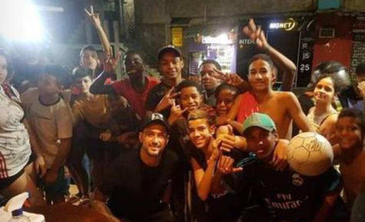 Sem máscara, Arrascaeta, do Flamengo, sobe a favela da Rocinha de moto e bate bola com moradores