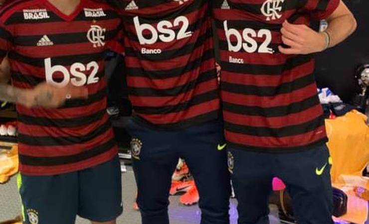 Filipe Luis veste a camisa do Flamengo ao lado de Paquetá e Daniel Alves